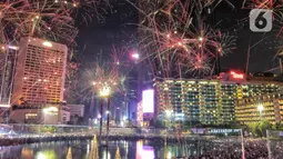 Warga menyaksikan pesta kembang api menyambut tahun baru 2023 di kawasan Bundaran HI, Jakarta, Senin (1/1/2023). Pemprov DKI Jakarta menggelar "car free night" hingga 1 Januari 2023 pukul 02.00 WIB dalam rangka menyambut tahun baru 2023. (Liputan6.com/Angga Yuniar)