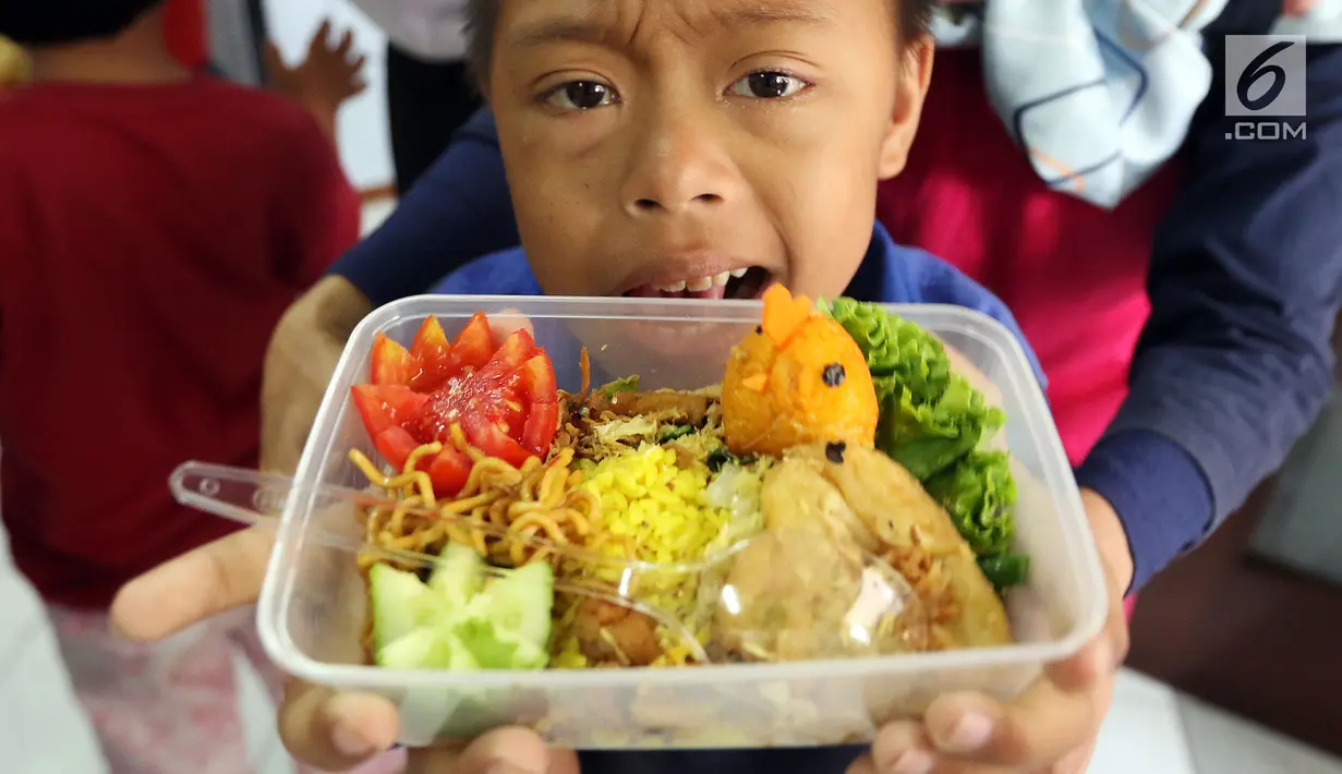 Anggota komunitas penyandang disabilitas, down syndrome, dan rungu wicara menunjukkan makanan saat mengikuti program kreativitas menghias Bekal Nusantara di Museum Naskah Proklamasi, Jakarta, Sabtu (14/9/2019). Mereka membuat makanan menggunakan bahan-bahan khas Indonesia. (Liputan6.com/JohanTallo)