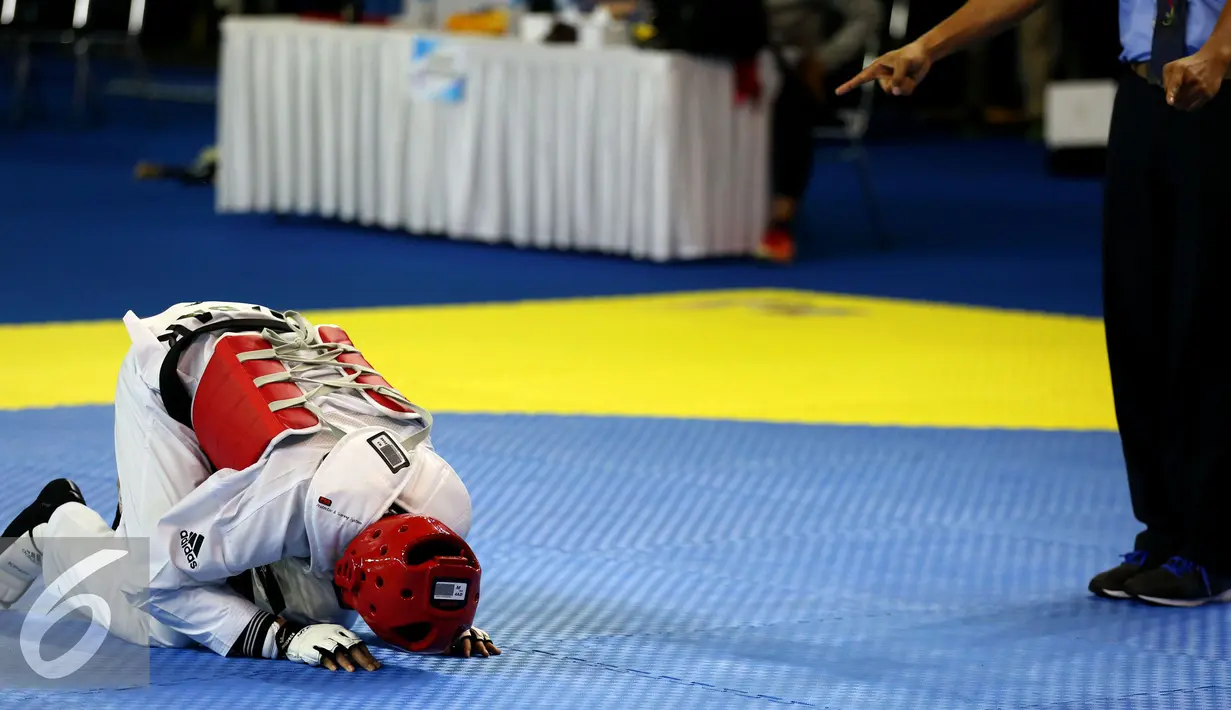 Taekwondoin Jawa Barat, Dinggo bersujud usai menumbangkan perlawanan Okky Indera P (DIY) pada final kelas -68kg PON XIX di Gymnasium UPI, Bandung, Senin (26/9/2016). Dinggo meraih emas setelah unggul 16-4. (Liputan6.com/Helmi Fithriansyah)