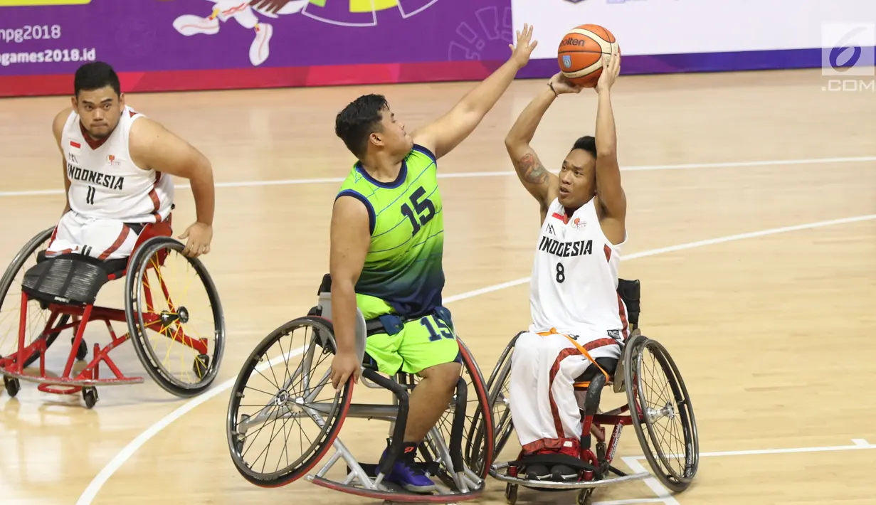 Pebasket difable Indonesia, Gusti Putu P Adriyana berebut bola dengan M Hafiz Ramli (Malaysia) pada laga Indonesia Para Games Invitational Tournament 2018 di Hall A Senayan, Jakarta, Minggu (1/7). Indonesia unggul 54-53. (Liputan6.com/Helmi Fithriansyah)