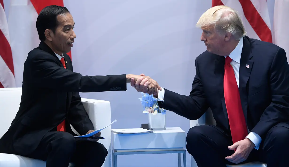 Presiden AS Donald Trump dan Presiden RI, Joko Widodo berjabat tangan saat bertemu di sela-sela KTT G20 di Hamburg, Jerman, (8/7). Sejumlah pemimpin negara berkumpul dalam KTT G20 pada 7-8 Juli 2017. (AFP Photo/Soul Loeb)
