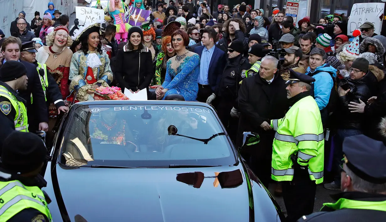 Aktris Mila Kunis berada di dalam mobil saat diarak dalam sebuah parade di Cambridge (25/1). Mila Kunis dinobatkan sebagai "Woman of the Year" oleh kelompok teater Hasty Pudding. (AP Photo / Charles Krupa)