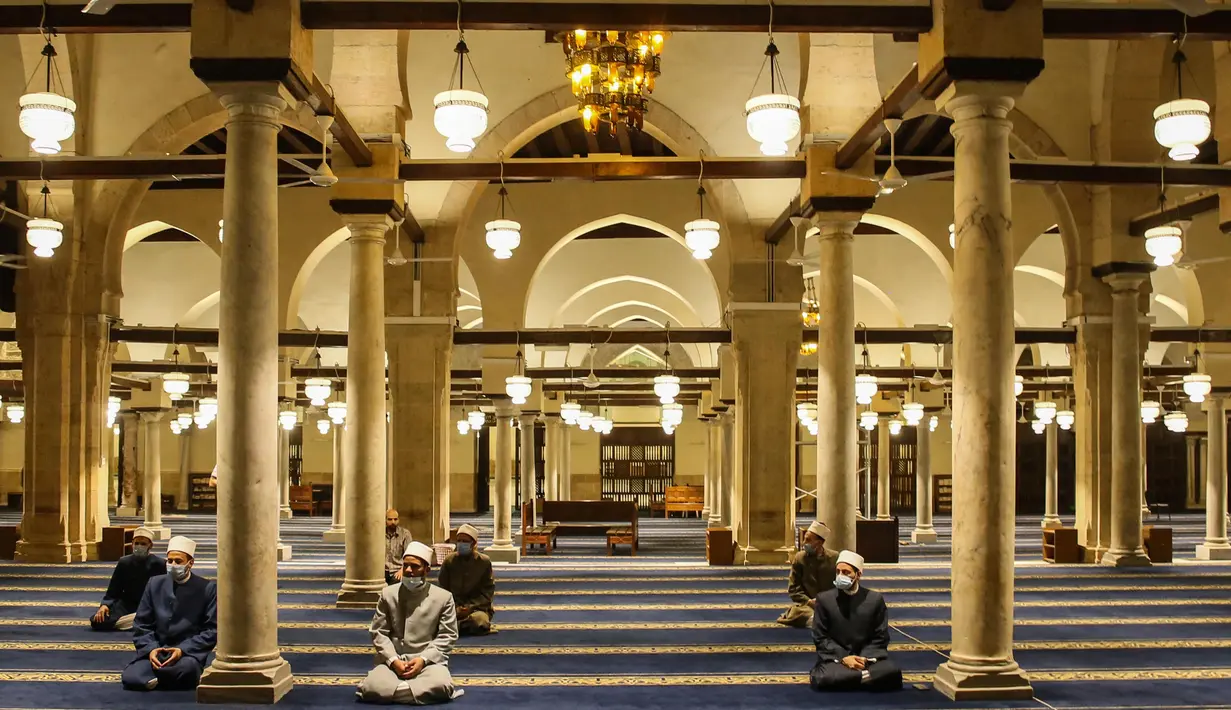 Umat Muslim doa setelah salat tarawih dengan menerapkan jaga jarak selama bulan Ramadan di Masjid al-Azhar, Kairo, Minggu (17/5/2020). Bagi umat Islam di seluruh dunia menjalankan ibadah puasa tahun ini di tengah pembatasan akibat corona Covid-19 adalah yang pertama kalinya. (Samer ABDALLAH/AFP)