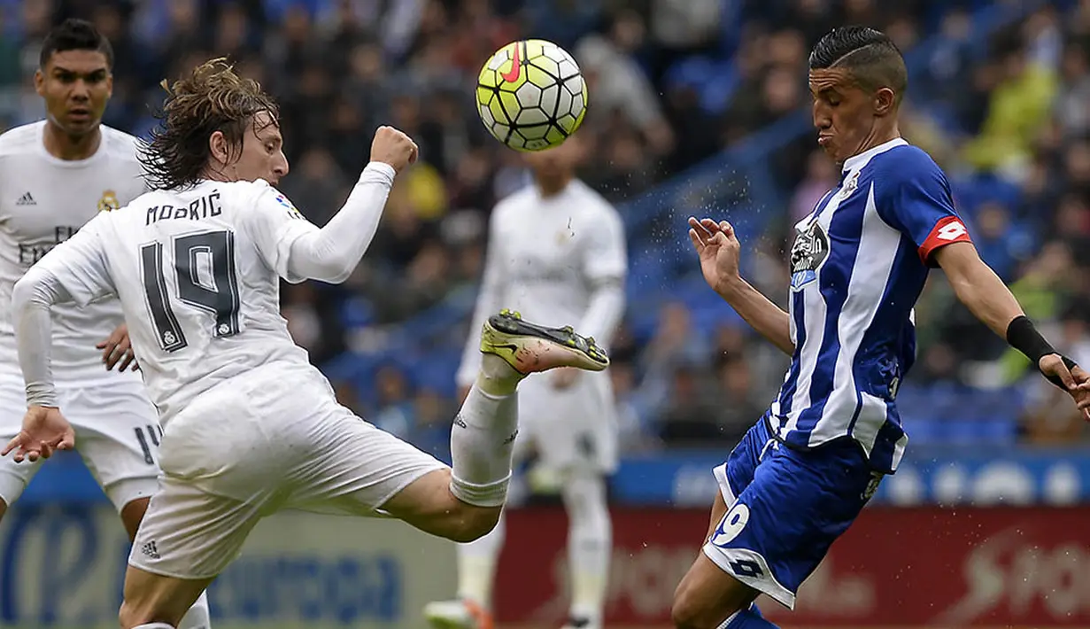 Gelandang Real Madrid, Luka Modric, berebut bola dengan gelandang Deportivo, Faycal Fajr, pada laga La Liga Spanyol. Meskipun menang Madrid gagal menjadi juara Liga Spanyol. (AFP/Miguel Riopa)