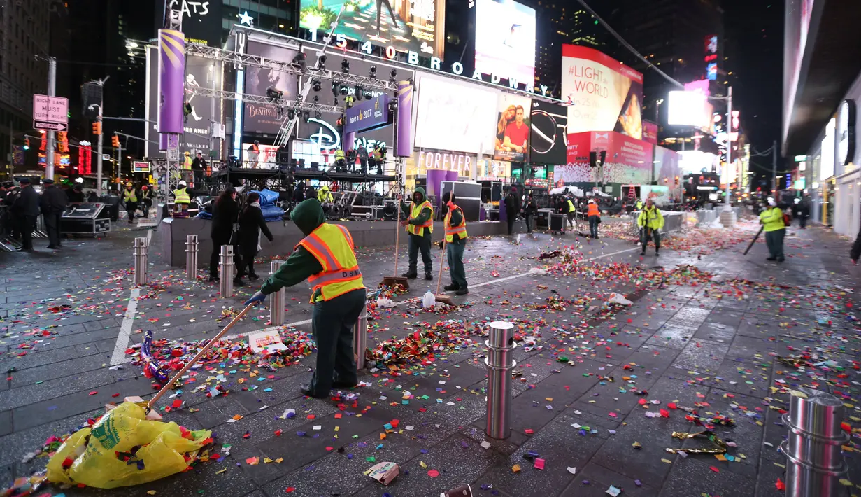 Petugas kebersihan setempat membersihkan sisa-sisa confetti setelah perayaan perayaan tahun baru di Times Square, New York, AS (1/1). (Reuters/ Stephen Yang)