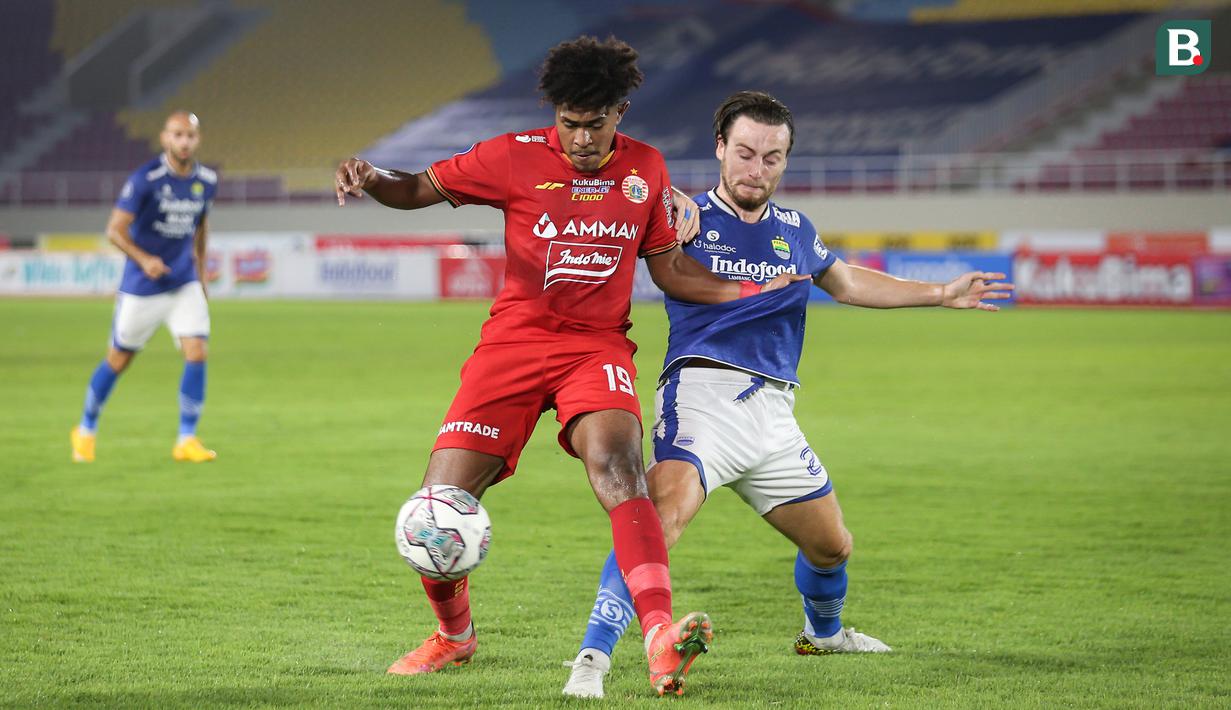 Pemain Persija Jakarta, Braif Fatari (kiri) berebut bola dengan pemain Persib Bandung, Marc Klok dalam laga pekan ke-12 BRI Liga 1 2021/2022 di Stadion Manahan, Solo, Sabtu (20/11/2021). (Bola.com/Bagaskara Lazuardi)