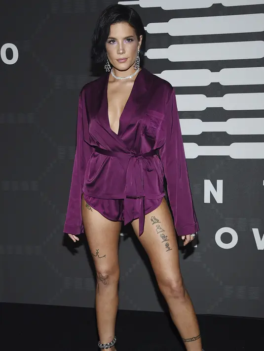 Penyanyi Halsey berpose saat tiba menghadiri Savage X Fenty Show yang disuguhkan oleh Amazon Prime Video di Barclays Center di Brooklyn, New York (10/9/2019). Halsey tampil seksi mengenakan gaun piyama sutra berwarna ungu dengan memamerkan tato di pahanya. (AP Photo/Evan Agostini)