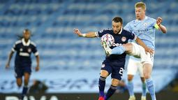 Pemain Manchester City Kevin De Bruyne (kanan) berebut bola dengan pemain Olympiacos Mathieu Valbuena pada pertandingan Grup C Liga Champions di Etihad Stadium di Manchester, Inggris, Selasa (3/11/2020). Manchester City mencukur Olympiacos dengan skor 3-0. (AP Photo/Dave Thompson)