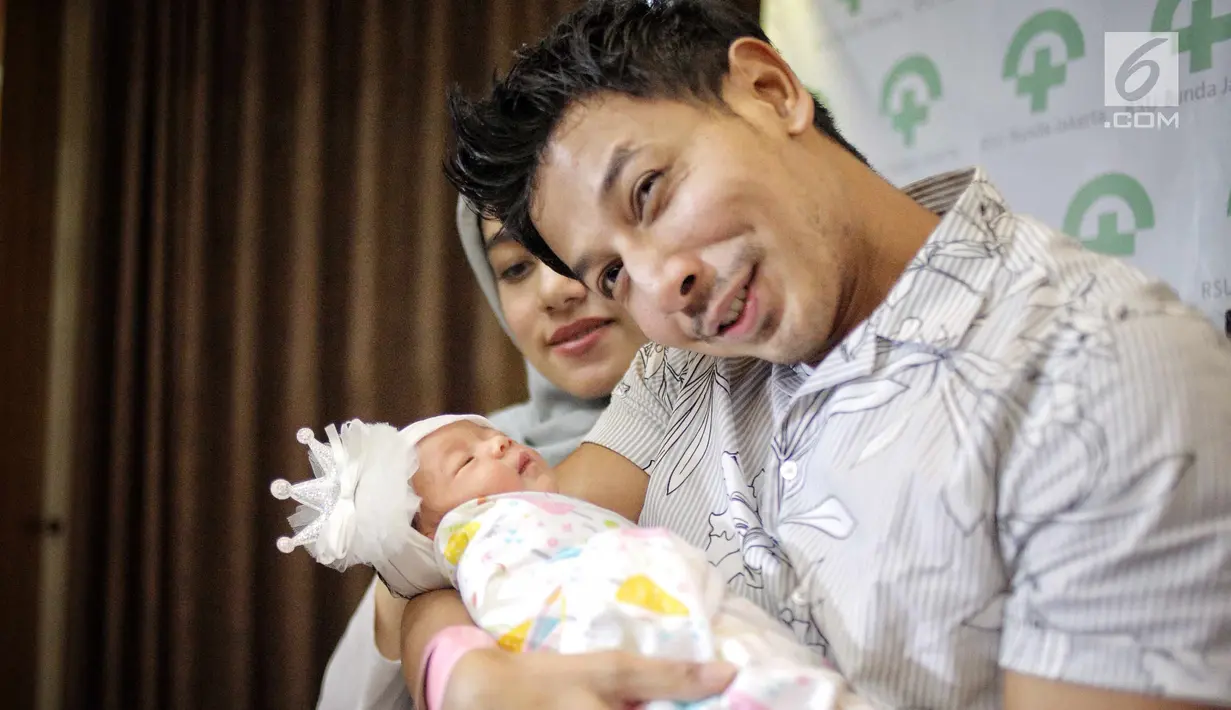 Senyum pasangan Fairuz A Rafiq dan Sonny Septian saat menunjukkan bayi perempuan mereka di Jakarta, Selasa (22/5). Fairuz melahirkan melalui operasi caesar. (Liputan6.com/Faizal Fanani)