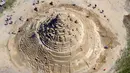 Pemahat beraktivitas di istana pasir tertinggi pada kompetisi tahunan "Sand Sculptures Festival" di Binz, Pulau Reugen di Laut Baltik, Jerman, 5 Juni 2019. Istana pasir karya seniman pasir bernama Thomas van Dungen itu didaulat sebagai istana pasir tertinggi yang pernah dibuat (Jens Büttner/dpa/AFP)