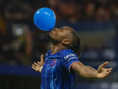 Pemain Chelsea, Christopher Nkunku melakukan selebrasi dengan meniup balon setelah mencetak gol ke gawang Servette pada leg pertama playoff UEFA Conference League 2024 di Stamford Bridge, London, Jumat (23/08/2024). (AP Photo/Alastair Grant)