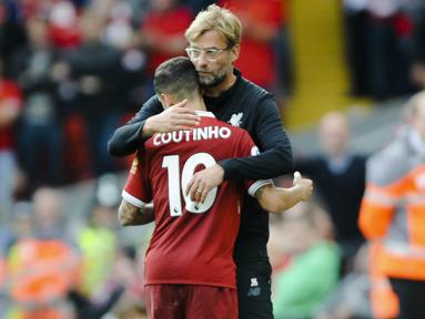 Pelatih Liverpool, Juergen Klopp, memeluk Philippe Coutinho saat melawan Manchester United pada laga Premier League di Stadion Anfield, Sabtu (14/10/2017). Liverpool bermain imbang 0-0 dengan Manchester United. (AP/Rui Vieira)