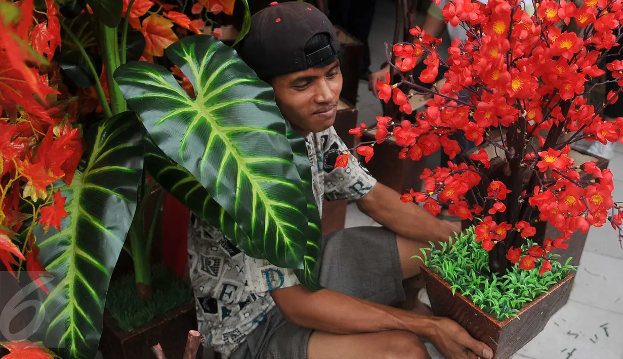 Pengrajin menunjukkan Pohon Hias Imlek di kawasan Glodok, Glodok, Jakarta, Kamis (21/1/2016). Penjual Pohon Hias Imlek mengaku kebanjiran order jelang perayaan Imlek. (Liputan6.com/Gempur M Surya)