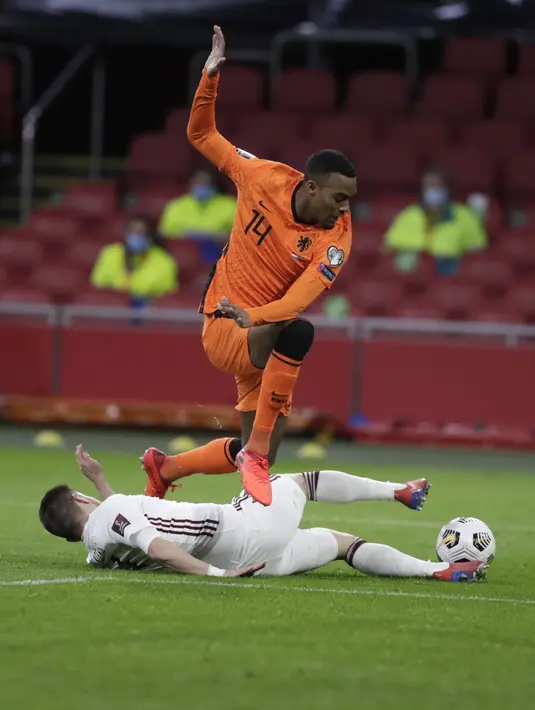 Gelandang Beland, Ryan Gravenberch berusaha melewati pemain Latvia, Roberts Savalnieks selama lanjutan Kualifikasi Piala Dunia 2022 zona Eropa Grup G di Johan Cruyff ArenA, Minggu (28/3/2021). Belanda sementara menguntit di posisi ketiga klasemen dengan tiga angka. (AP Photo/Peter Dejong)