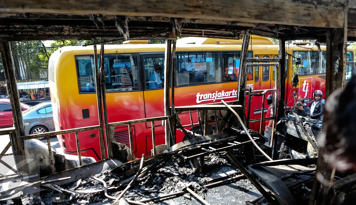 Penumpang bus melihat dari balik jendela sisa Bus Transjakarta yang terbakar di Halte UI Salemba, Jakarta, Jumat (3/7). Bus Koridor V jurusan Ancol-Kampung Melayu tersebut terbakar sekitar pukul 08.30 WIB. (Liputan6.com/Faizal Fanani)