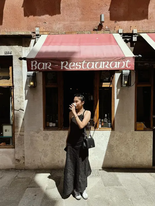 Azizah Salsha jadi turis fashionable dengan halterstrap dress hitam dan tas Chanel Boy Rp116jutaan. [@azizahsalsha_]