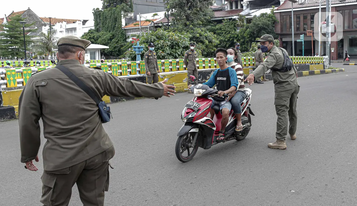 Petugas Satpol PP memberhentikan pengendara sepeda motor saat melakukan razia masker di kawasan Kota Tua, Jakarta, Kamis (24/2/2022). Pemerintah pusat kembali memperpanjang masa PPKM level 3 untuk wilayah Jakarta, Bogor, Depok, Tangerang dan Bekasi (Jabodetabek). (Liputan6.com/Faizal Fanani)