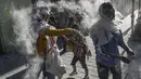 Orang-orang bermain dengan bedak dan busa di jalan selama Karnaval Hitam Putih di Pasto, Kolombia (6/1/2022). Karnaval Hitam Putih, yang telah asal-usulnya dalam campuran ekspresi budaya Andes, Amazon, dan Pasifik. (AFP/Joaqin Sarmiento)
