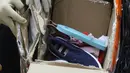 Petugas menunjukkan barang bukti kardus berisi sepatu sandal saat rilis penyelundupan 68 kg katinon dan 15.487 butir pil ekstasi dengan 11 tersangka di Kantor Pusat Bea Cukai, Jakarta, Senin (28/5). (Liputan6.com/Arya Manggala)