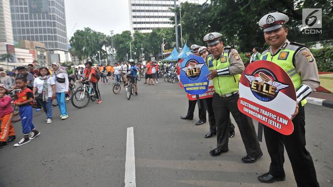 Polisi menyosialisasikan sistem Electronic Traffic Law Enforcement (ETLE) kepada warga di kawasan Bundaran HI, Jakarta, Minggu (25/11). Sistem ini akan merekam bukti pelanggaran lalu lintas. (Merdeka.com/Iqbal Nugroho)