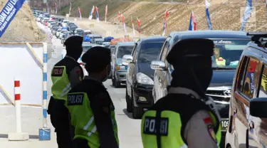 Petugas kepolisian mengatur kendaraan yang melintasi Tanjakan Kali Kenteng di jalan tol fungsional Salatiga-Boyolali, Jawa Tengah, Senin (18/6). Jalan tol ini akan dibukan selama 24 jam selama arus balik Lebaran 2018. (Liputan6.com/Gholib)