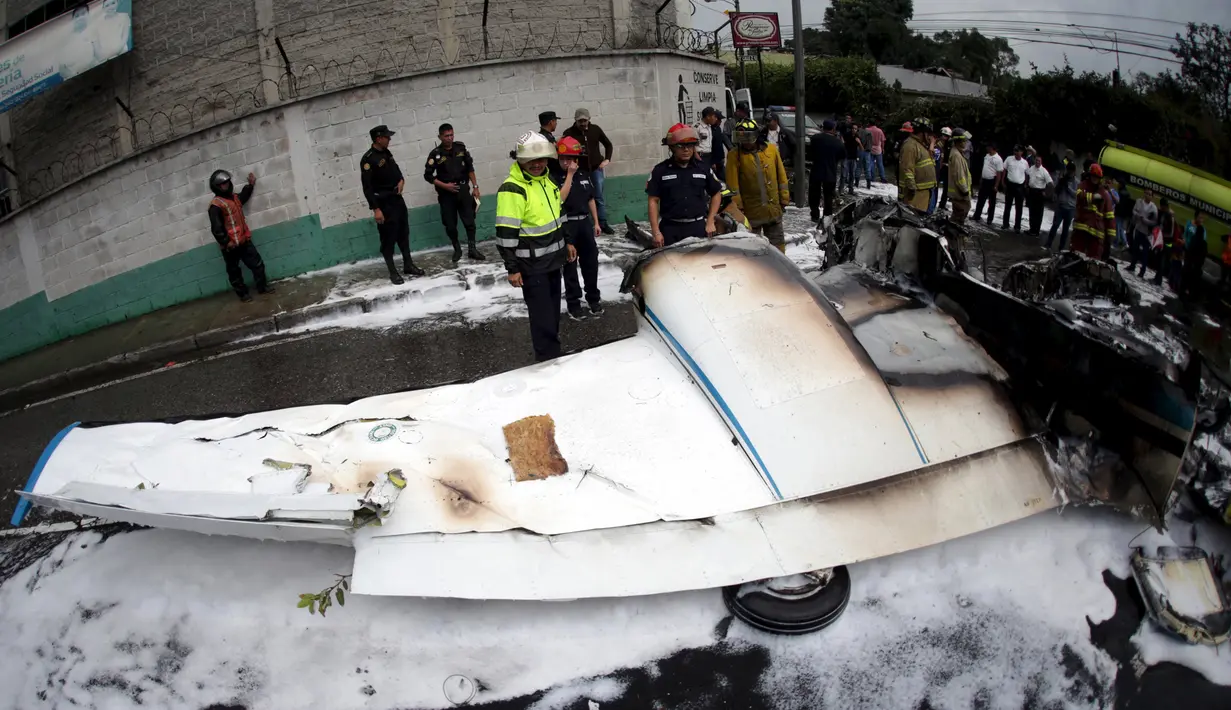Petugas Polisi berjaga disamping bangkai pesawat yang hangus terbakar di Guatemala City, Guatemala, Sabtu (21/11/2015). Pesawat terjatuh setelah lepas landas dari Bandara Internasional La Aurora. (REUTERS/Jorge Dan Lopez)