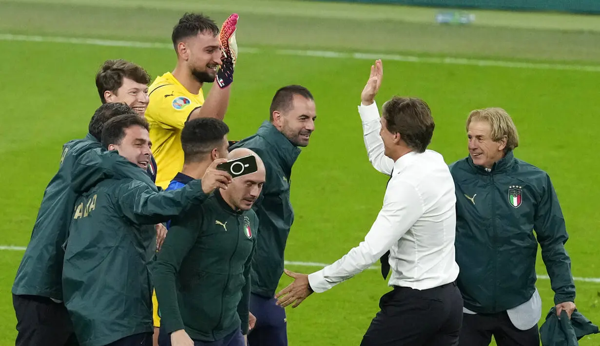 Pelatih Italia, Roberto Mancini (kedua kanan) memberi selamat kepada kiper Gianluigi Donnarumma setelah semifinal Euro 2020 melawan Spanyol di Stadion Wembley, London, Inggris, Rabu (7/7/2021). Italia akan bertemu antara pemenang Inggris vs Denmark di babak final. (AP Photo/Matt Dunham,Pool)