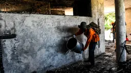 Seorang petugas pemadam kebakaran memadamkan sisa api di dalam Panti Asuhan Church of Bible Understanding, pinggiran Port-au-Prince di ibu kota Haiti, Jumat (14/2/2020). Panti asuhan yang sudah tidak berizin sejak 2013 itu menampung sekitar 66 anak-anak. (CHANDAN KHANNA/AFP)