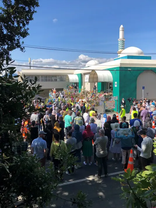 Orang-orang membentuk rantai manusia untuk melindungi jemaah salat Jumat di Hagley Park luar masjid Al-Noor, di Christchurch, Selandia Baru, Jumat (22/3). Ibadah itu digelar sepekan selepas penembakan brutal di kota Christchurch. (Sue Teodoro via REUTERS)