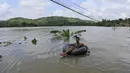 Seorang warga berada di atas ban saat banjir melanda Sri Lanka, Minggu (28/5). Pejabat Sri Lanka menyebut mayoritas para korban tewas berada di wilayah Distrik Kalutara. (AP Photo)