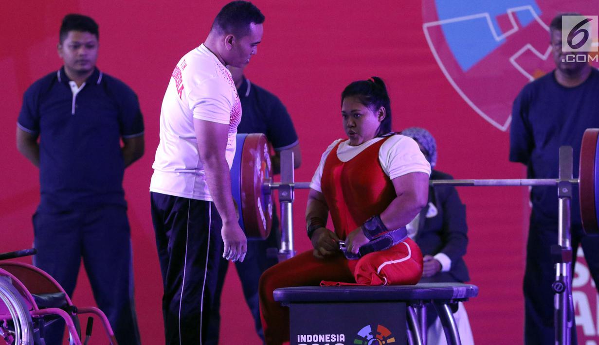 Atlet Para Powerlifting Indonesia, Siti Mahmudah bersiap melakukan angkatan beban di kelas Womens Up 79kg Asian Para Games 2018 di Jakarta, Rabu (10/10). Siti Mahmudah meraih perak dengan total angkatan 120 kg. (Liputan6.com/Helmi Fithriansyah)