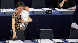 Anggota Parlemen Eropa Anneliese Dodds saat mencoba mendiamkan anaknya yang diajak rapat di kantor Parlemen Eropa, Strasbourg , Perancis , 14 April 2016. Wanita ini tampak santai menikmati rapat sambil mengasuh anaknya.  (REUTERS / Vincent Kessler)