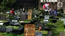 Sejumlah warga berziarah di makam keluarganya di Tempat Pemakaman Umum (TPU) Tanah Kusir, Jakarta, Selasa (29/3/2022). TPU setempat semakin banyak dikunjungi warga yang melakukan tradisi ziarah kubur menjelang Ramadhan. (Liputan6.com/Johan Tallo)