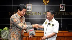 Ketua Komnas HAM, Imdadun Rahmat (kiri) menerima buku Palu dan Godam Melawan Keangkuhan dari Rusdy Mastura di Jakarta, Rabu (29/6). Buku itu kisah di balik permohonan maaf kepada korban pelanggaran HAM 1965-1966. (Liputan6.com/Helmi Fithriansyah)