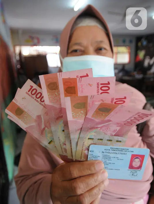 Warga penerima bantuan menunjukkan uang tunai saat penyaluran Bantuan Sosial Tunai (BST) di SDN Pondok Cabe Udik 03, Tangerang Selatan, Rabu (28/07/2021). Lebih dari dari 1800 warga mendapatkan BST yang dirapel dua bulan sekaligus dengan total Rp600ribu. (merdeka.com/Arie Basuki)