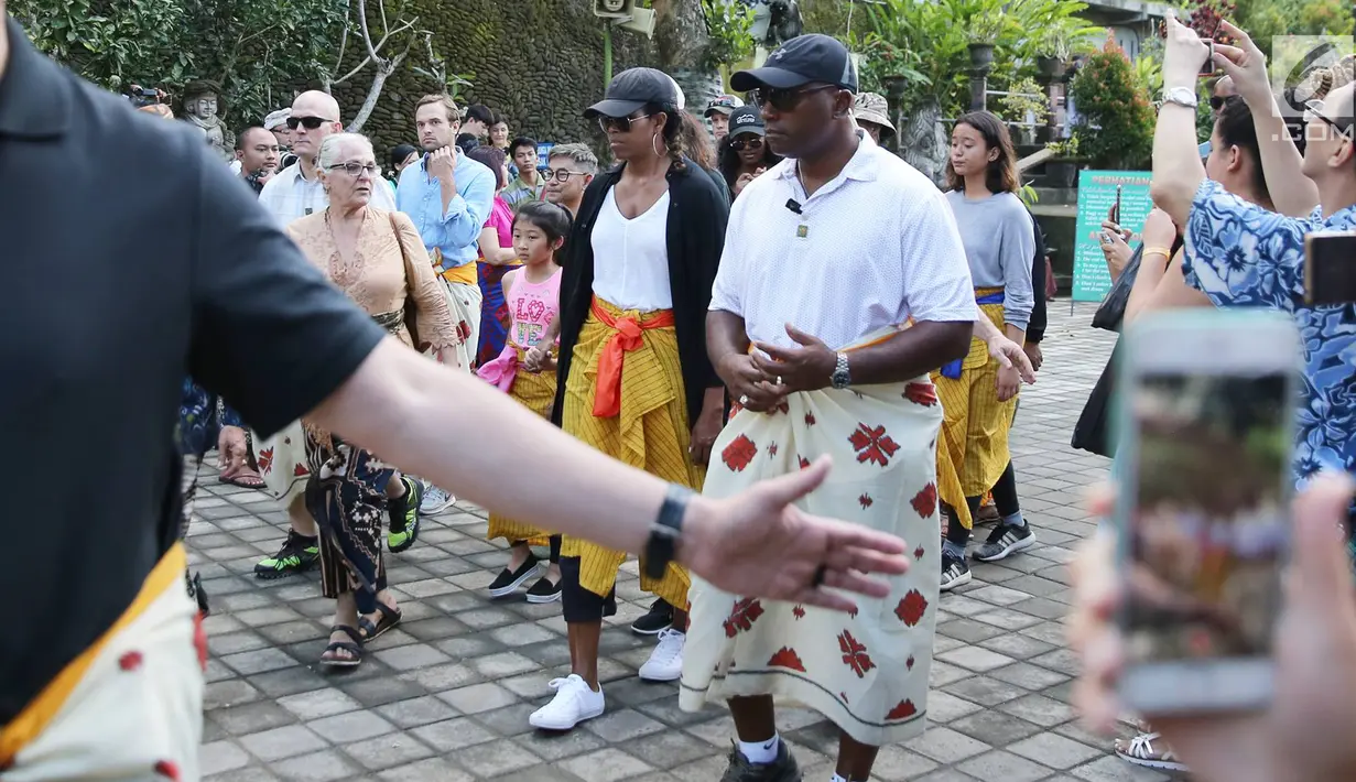 Istri Presiden ke-44 AS Barack Obama, Michelle Obama, mengunjungi Pura Tirta Empul, Tampaksiring, Gianyar, Bali, Selasa (27/6). Sama seperti pengunjung pura pada umumnya, Michelle Obama pun mengenakan sarung warna kuning.  (Liputan6.com/Immanuel Antonius)