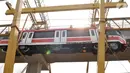 Proses perdana gerbong kereta layang ringan atau light rail transit (LRT) ke lintasan rel di Stasiun Harjamukti, Cibubur, Minggu (13/10/2019). Sebanyak satu rangkaian (trainset) yang terdiri dari 6 kereta (car) diangkat ke atas rel menggunakan Gantry Crane. (merdeka.com/Iqbal S Nugroho)