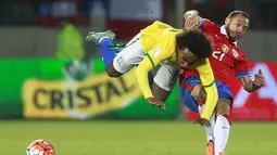 Pemain Brazil Willian (kiri) terjungkal saat berebut bola dengan pemain Chile Marcelo Diaz pada laga kualifikasi Piala Dunia 2018 di Santiago, Chile, Kamis (08/10/2015). Chile menang 2-0.   (AFP Photo / Claudio Reyes)