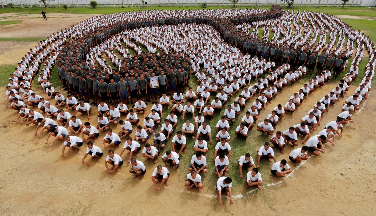 Para narapidana membentuk formasi angka sembilan Thailand untuk menghormati mendiang Raja Thailand Bhumibol Adulyadej di penjara Pathum Thani, Bangkok, Thailand (27/10). Raja Bhumibol juga dikenal sebagai Raja Rama IX. (Reuters/Chaiwat Subprasom)