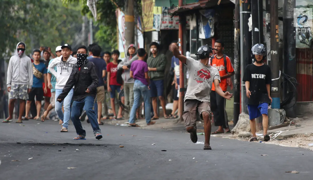 Massa melempar batu ke arah aparat keamanan saat terjadi bentrok di kawasan Slipi, Jakarta Barat, Rabu (22/5/2019). Massa yang terlibat kerusuhan tarpantau sebagian besar masih berusia remaja. (Liputan6.com/Gempur Muhammad Surya)
