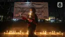 Massa menggelar aksi dengan membawa lilin dan doa bersama lintas agama di depan Gedung DPR, Jakarta, Kamis (16/3/2023). Dalam aksinya, mereka menuntut agar pimpinan DPR menetapkan RUU PPRT sebagai RUU INISIATIF DPR di Rapat Paripurna pada Selasa, 21 Maret 2023 mendatang. (Liputan6.com/Johan Tallo)
