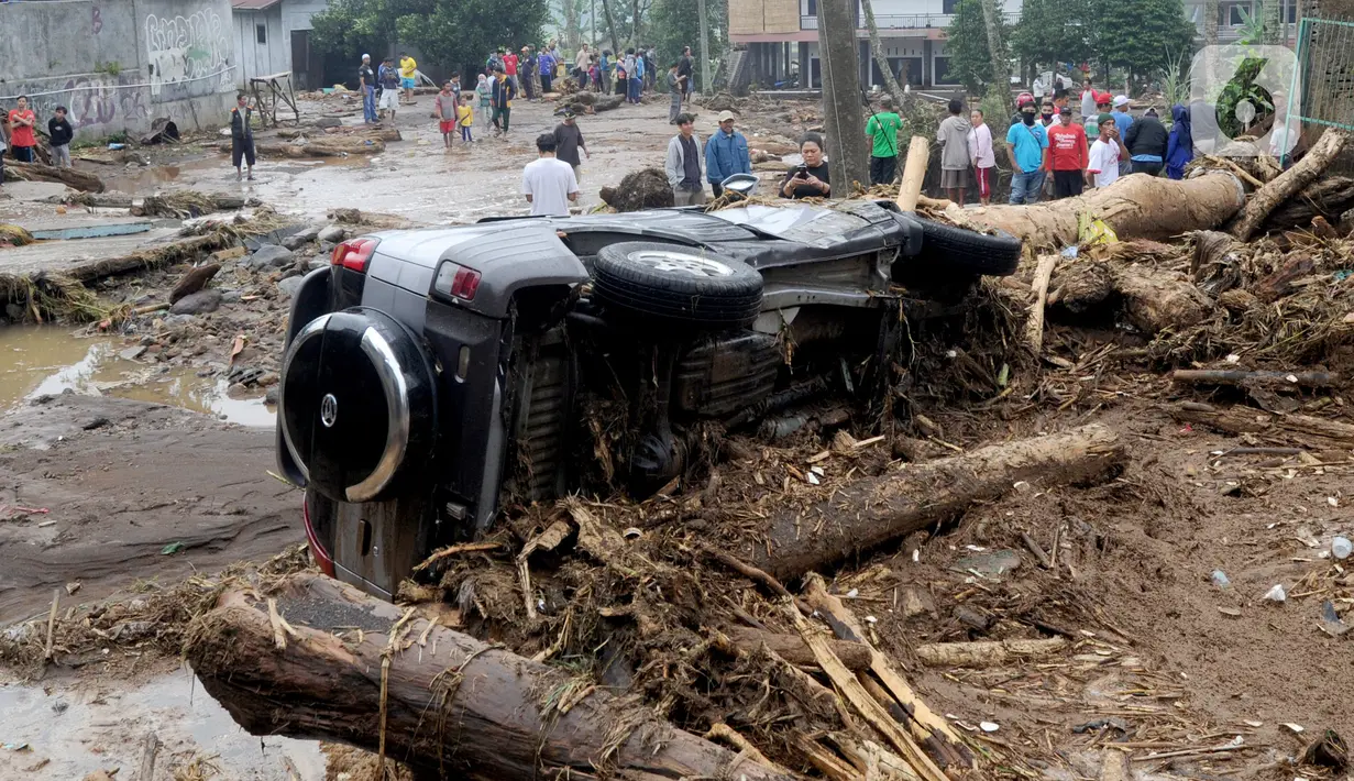 Sebuah mobil terguling usai banjir bandang melanda Kampung Cibuntu, Desa Pasawahan, Kecamatan Cicurug, Sukabumi, Jawa Barat, Selasa (22/9/2020). Data sementara puluhan bangunan rusak berat, 12 rumah hanyut, dan dua korban hilang masih dicari. (merdeka.com/Arie Basuki)