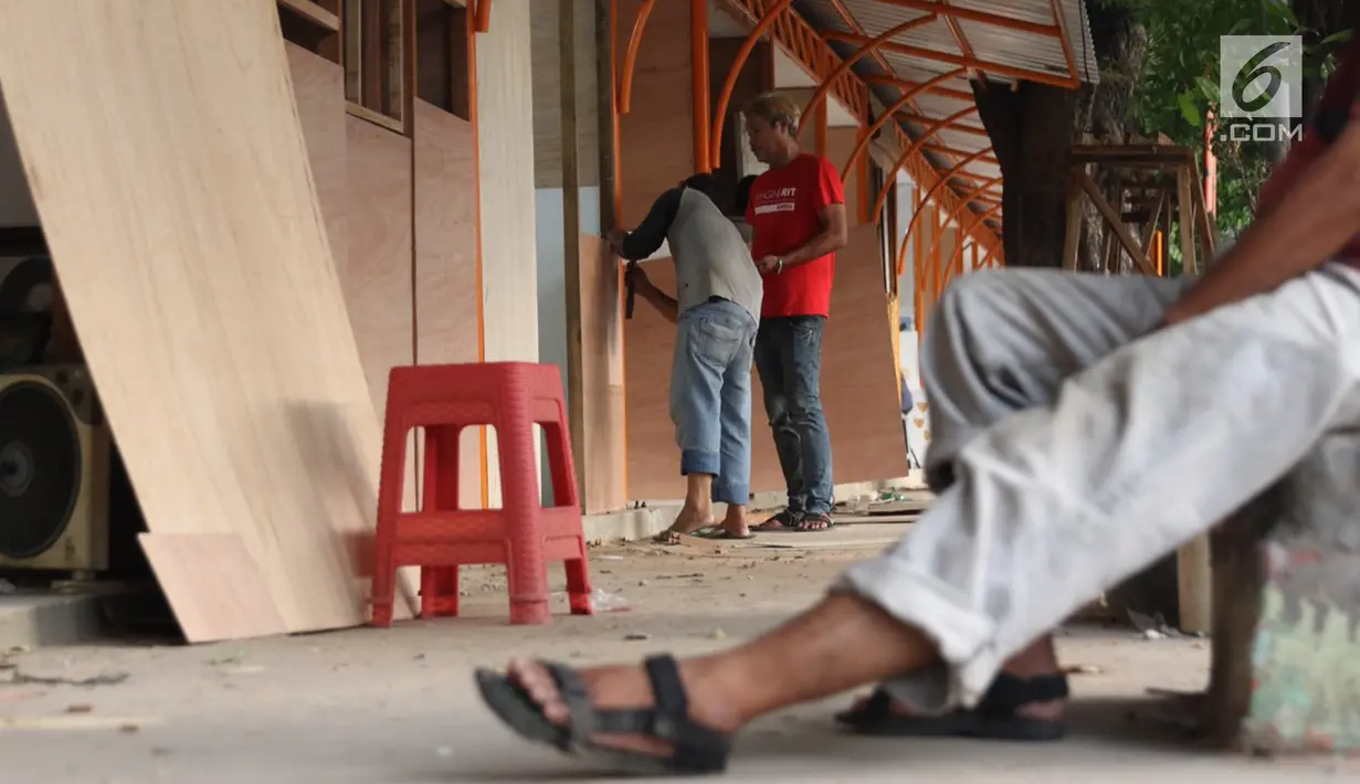 Seniman lukis memasang dinding lapak kios di Sentra Lukisan Pasar Baru, Jakarta, Jumat (16/11). Sejumlah seniman lukis mengeluhkan kondisi lapak Sentra Lukisan Pasar Baru. (Liputan6.com/Immanuel Antonius)