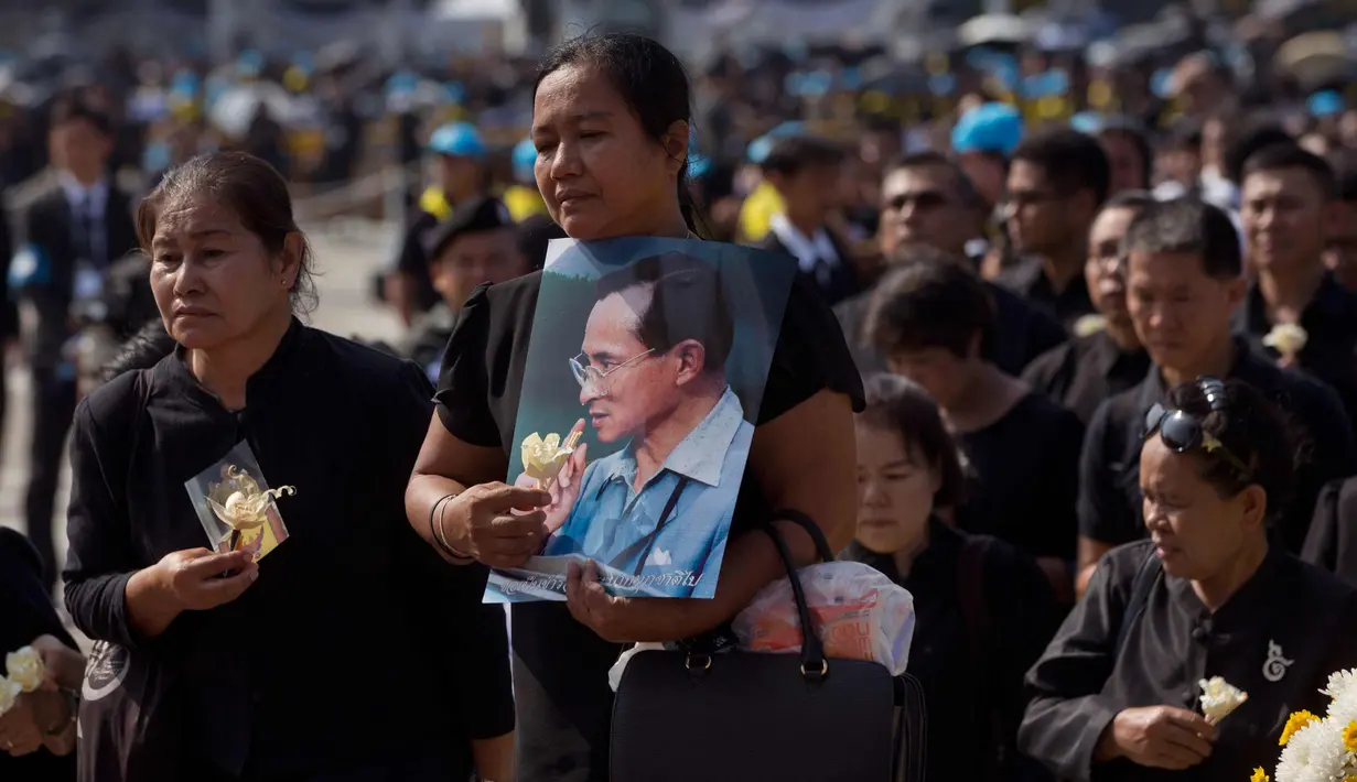 Kesedihan sejumlah warga saat upacara kremasi mendiang Raja Bhumibol Adulyadej di Bangkok, Thailand, Kamis, (26/10). Prosesi kremasi Raja Bhumibol dilaporkan telah menelan biaya hingga Rp1,2 triliun. (AP Photo/Gemunu Amarasinghe)