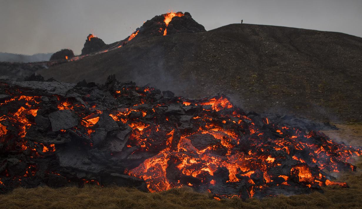 Aliran lava dari letusan gunung berapi di Semenanjung Reykjanes di barat daya Islandia pada Sabtu (20/3/2021). Erupsi Gunung berapi yang tertidur lama alias tidak aktif selama 6.000 tahun tidak mempengaruhi lalu lintas penerbangan. (AP Photo/Marco Di Marco)