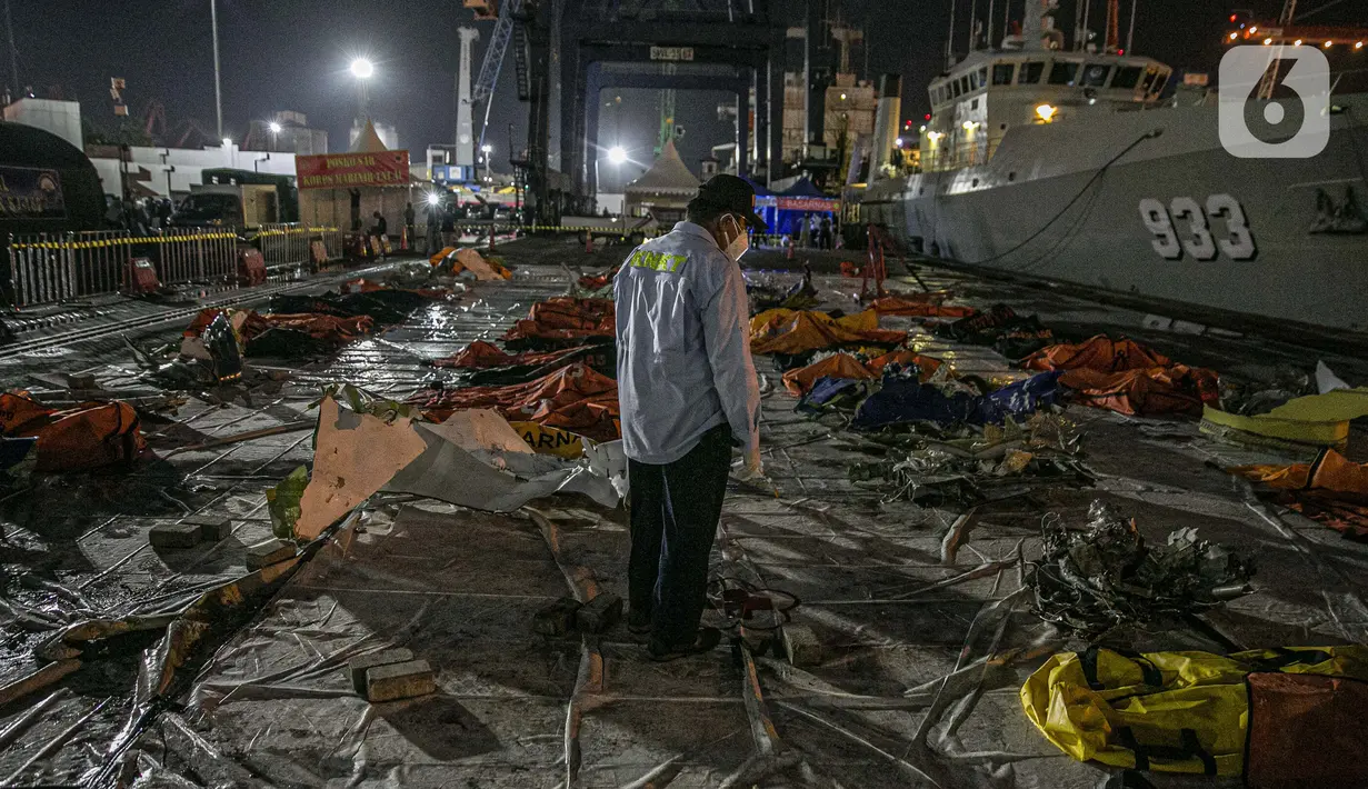 Petugas memeriksa serpihan Sriwijaya Air SJ 182 untuk diangkut di Terminal JICT 2, Tanjung Priok, Jakarta, Kamis (21/1/2020).  Serpihan Sriwijaya Air SJ 182 dipindahkan dari Terminal JICT 2 ke kantor KNKT untuk dilakukan pemeriksaan dan identifikasi. (Liputan6.com/Faizal Fanani)