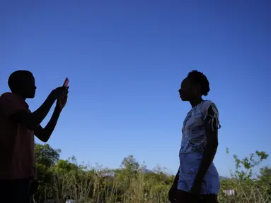 Seorang penduduk mengambil foto saudaranya dari ponselnya di Kalunga quilombo, di daerah pedesaan Cavalcante di negara bagian Goias, Brasil, Senin (15/8/2022). Nenek moyang penduduk desa Kalunga quilombo menetap di sana sebagai budak yang melarikan diri lebih dari 200 tahun yang lalu. (AP Photo/Eraldo Peres)