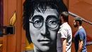 Mural potret John Lennon saat Festival Aliados di San Jose, Costa Rica (11/3). Acara ini bertujuan untuk memperat hubungan antar negara khusus para seniman mural. (AFP Photo/Ezequiel Becerra)