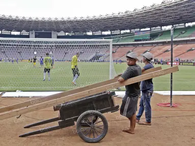 Pekerja pengangkut pasir menikmati tontonan gratis saat Persib Bandung berlatih di Stadion Utama Gelora Bung Karno, Jakarta, Sabtu (2/4/2016). (Bola.com/Nicklas Hanoatubun)
