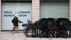Seorang wanita berjalan di depan toko pakaian yang tutup di pusat kota di Munich, Jerman, Selasa (23/3/2021). Jerman memperpanjang tindakan pengunciannya sebulan lagi. (AP Photo/Matthias Schrader)